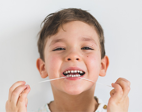 Young boy flossing his teeth