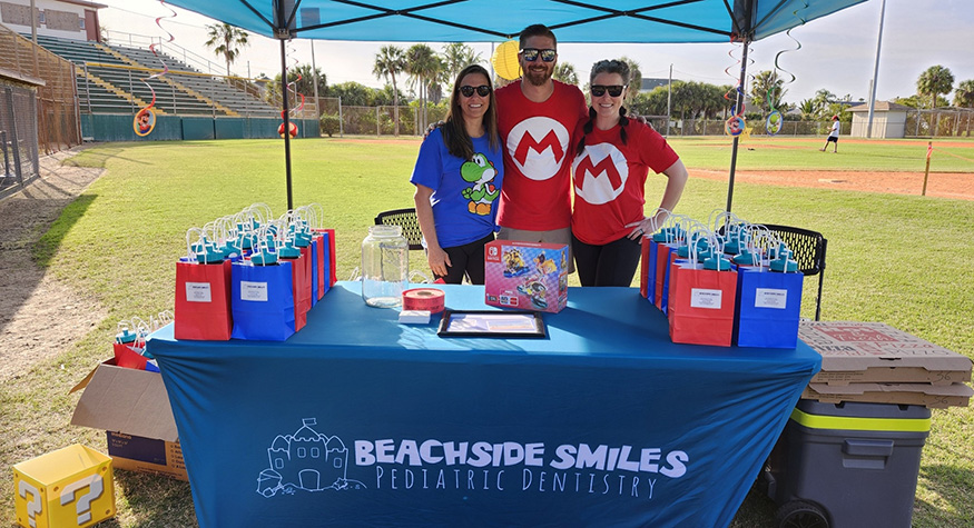 Beachside Smiles Pediatric Dentistry team wearing Mario themed shirts at outdoor event