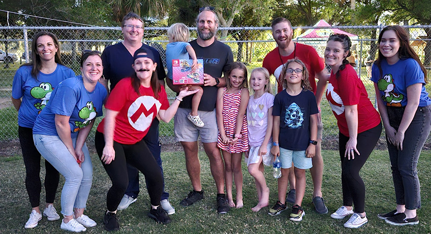 Pediatric dental team members and a few kids with a Mario Switch game