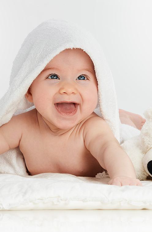 Happy baby playing on white rug