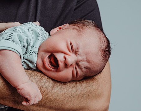 Father trying to comfort crying baby