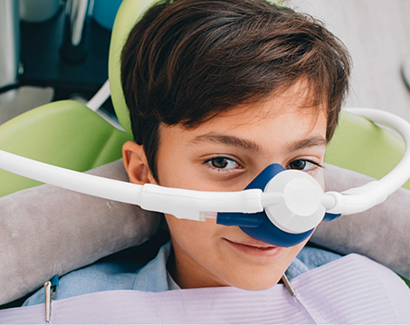 Boy in dental chair with nitrous oxide mask on his nose