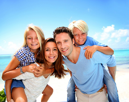 Family of four smiling at the beach